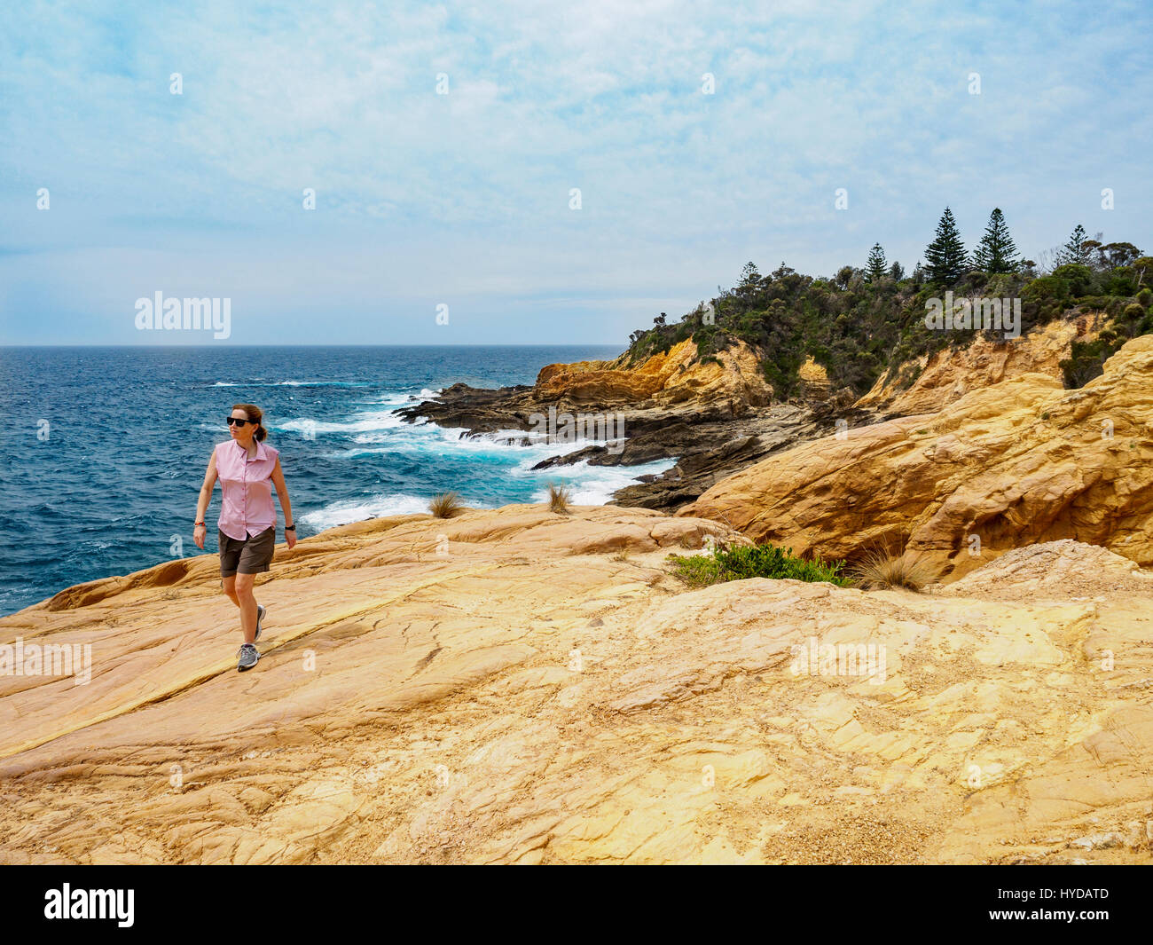 Australien, New South Wales, Bermagui, Frau, die an der Küste läuft Stockfoto