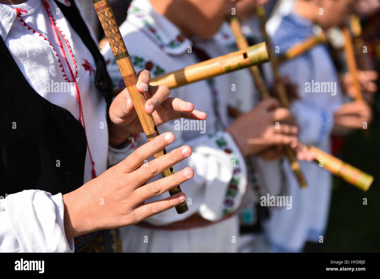 Menschen in rumänischen Trachten singen bei Holzflöten Stockfoto