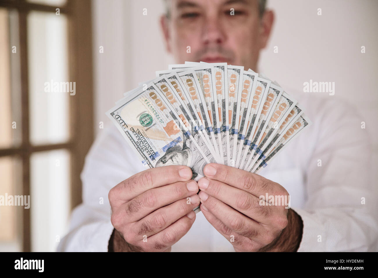 Ein Mann fans zwei Hände voll von neuen Hundert-Euro-Scheine in US-Währung Stockfoto