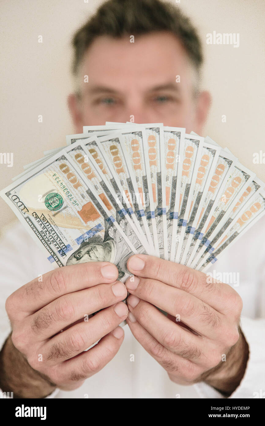 Ein Mann fans zwei Hände voll von neuen Hundert-Euro-Scheine in US-Währung Stockfoto