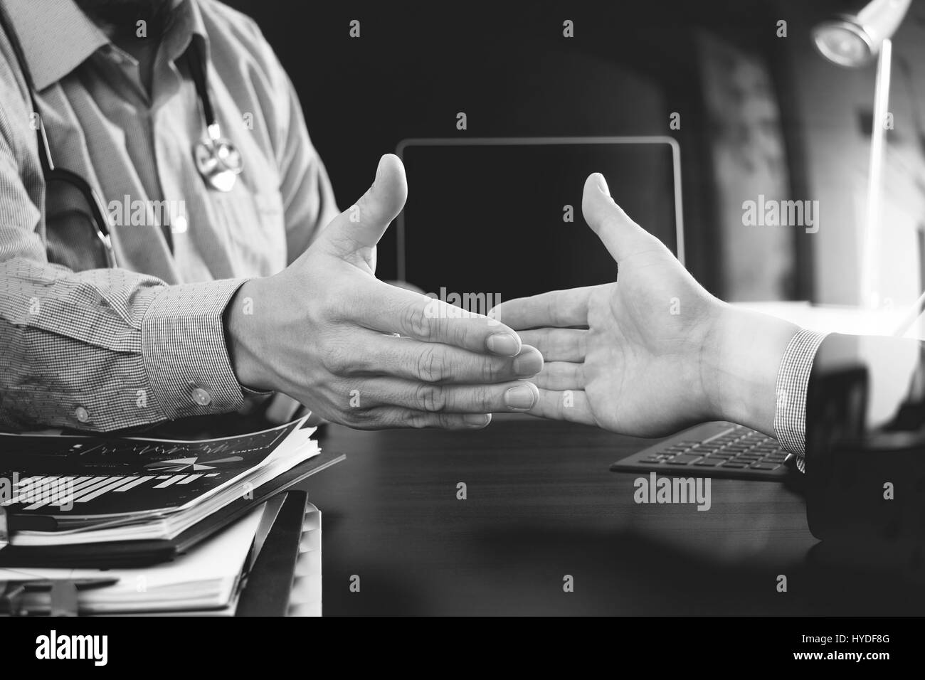 Medizin- und Gesundheitswesen Konzept, Arzt und Patient Händeschütteln in modernen Büro im Krankenhaus, schwarz / weiß Stockfoto