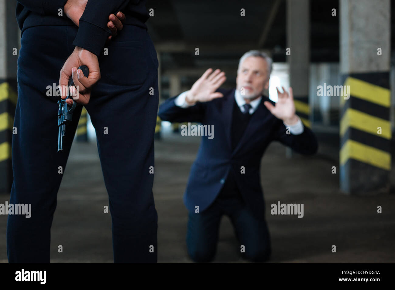 Selektiven Fokus einer Handfeuerwaffe, die hinter dem Rücken gehalten wird Stockfoto