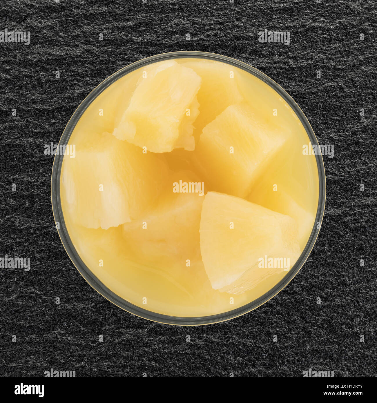Draufsicht der Ananas Stücke in eine Glasschüssel auf Schiefer Tisch. Stockfoto