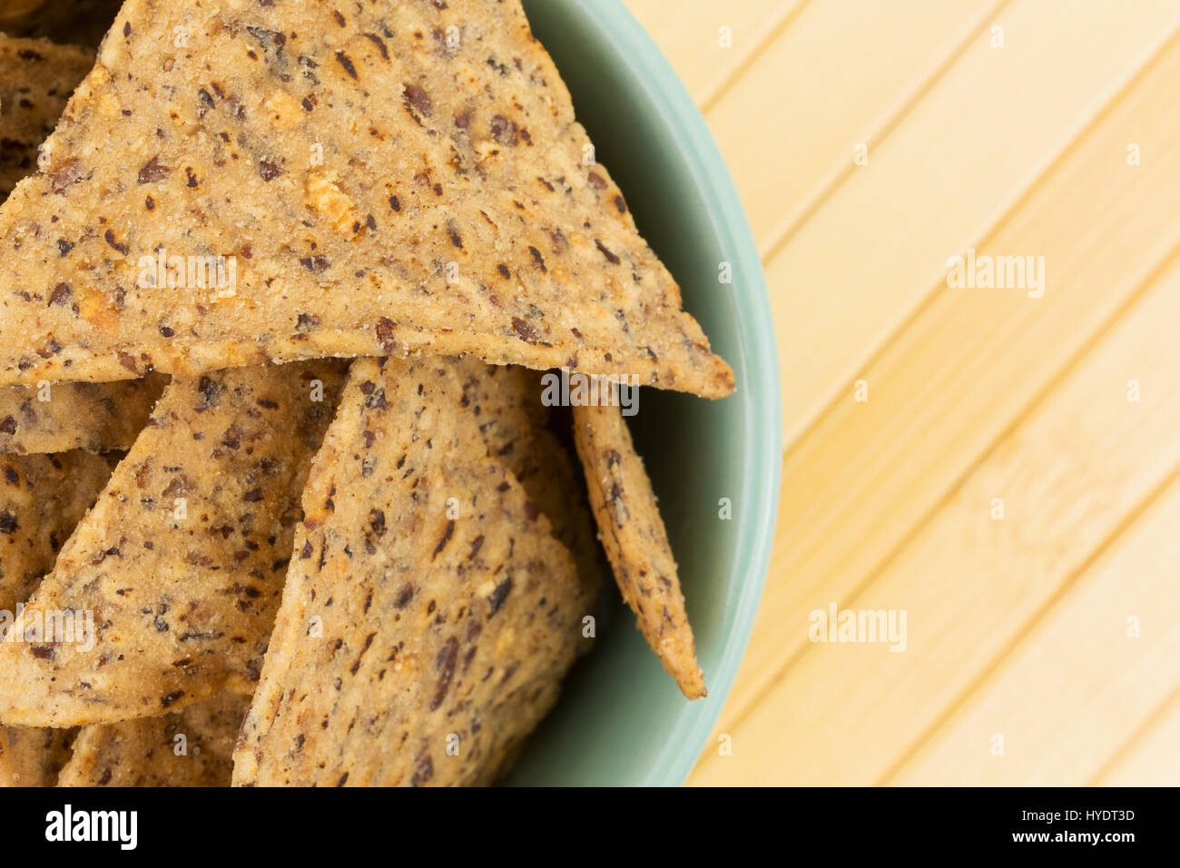 Enge Draufsicht einer Schüssel gefüllt mit Salz und Pfeffer gewürzte Bohnen und Reis Chips auf einem Holz-Platz-Matte. Stockfoto