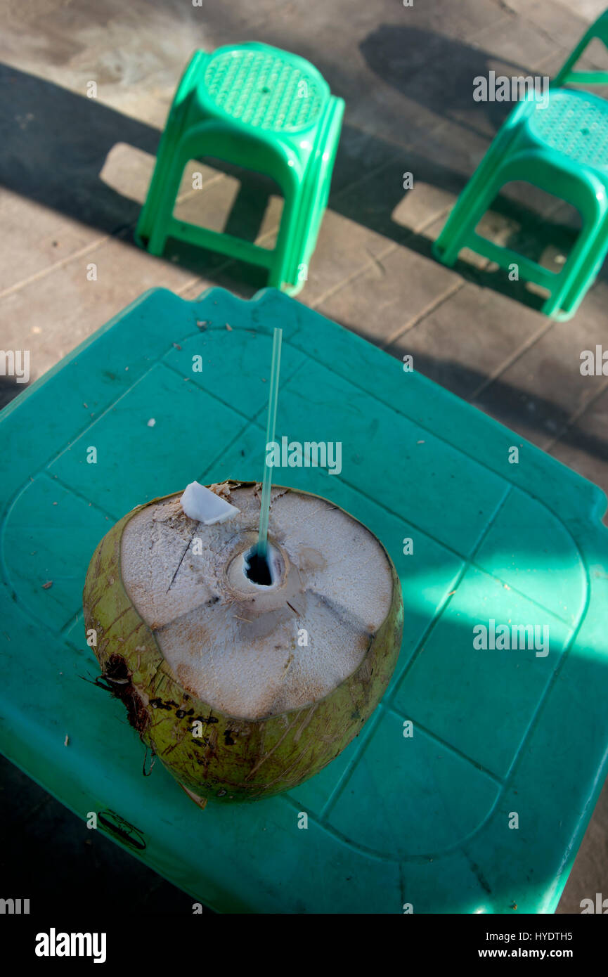 Myanmar (Burma). Yangon. Kokosnuss am grünen Tisch mit grünen Plastikstühlen. Stockfoto