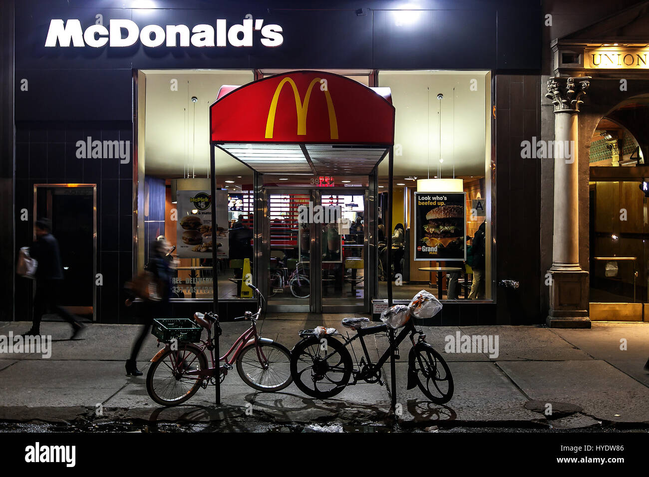 Menschen gehen von einem McDonald's Fast Food Restaurant in Manhattan. Stockfoto