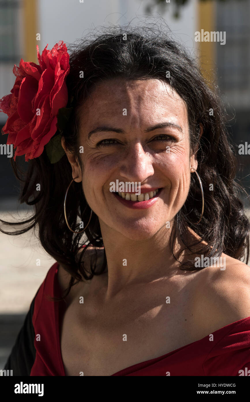 Eine spanische Frau gekleidet wie eine Flamenco-Tänzerin, eine große rote rose im Haar tragen, während der Wartezeit für eine Gruppe von Schulkindern eine Geschichte Les geben Stockfoto