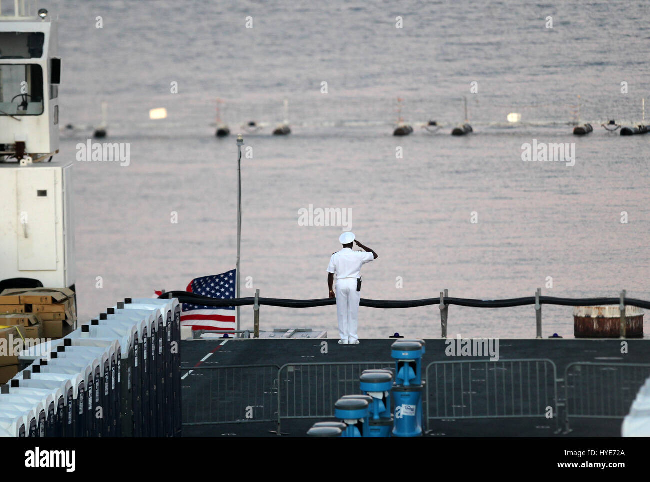 10. November 2012 Marineoffizier grüßt die amerikanische Flagge, da es aus Thedeck der USS Battan vor Sonnenuntergang der Navy Marine Corps Classic am Naval Station Mayport in Jacksonville, FL Kredit gesenkt wird: mpi34/MediaPunch Inc Stockfoto