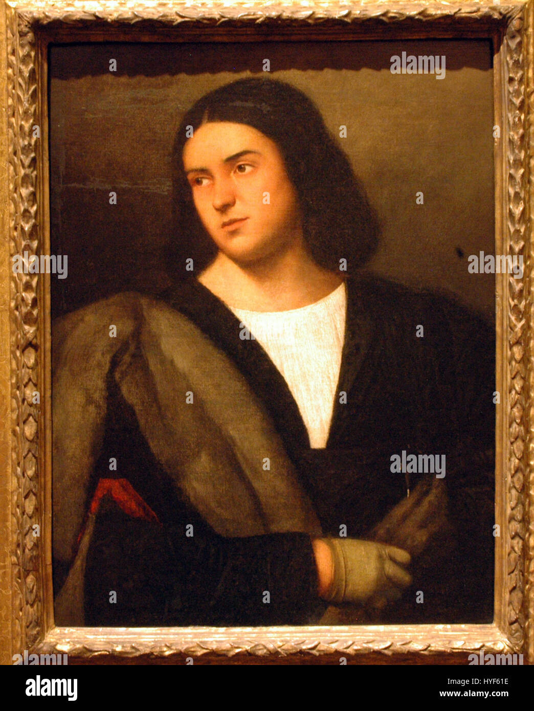 Dieses um 1520 datierte Porträt zeigt einen jungen Mann in Renaissancebekleidung. Das Gemälde unterstreicht die detaillierte Verwendung von Ölfarben und die zunehmende Betonung realistischer Porträtmalereien während der frühen Renaissance. Stockfoto