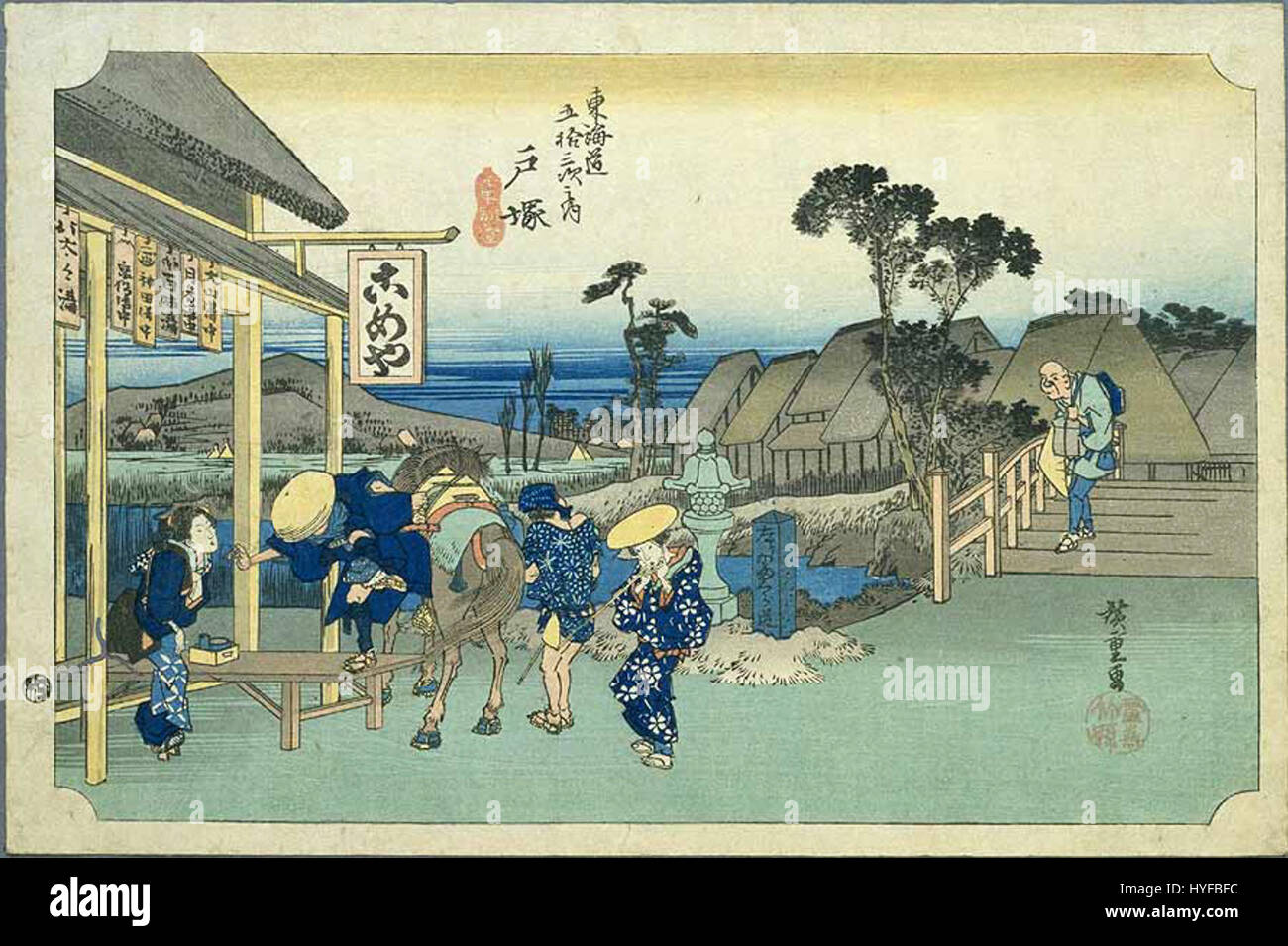 Dieses Kunstwerk aus der „Tokaido“-Serie, das den Bahnhof Totsuka darstellt, fängt die geschäftige Aktivität des frühen modernen Japans ein. Der Druck zeigt das tägliche Leben entlang der Tokaido-Straße während der Edo-Zeit und zeigt den kulturellen Reichtum und die Details der Epoche. Stockfoto