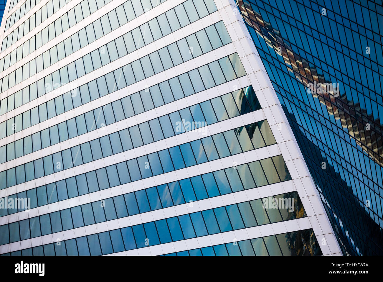 Glas-Fassade des Bürogebäudes an einem sonnigen Tag mit Reflexion der Wolkenkratzer. Stockfoto