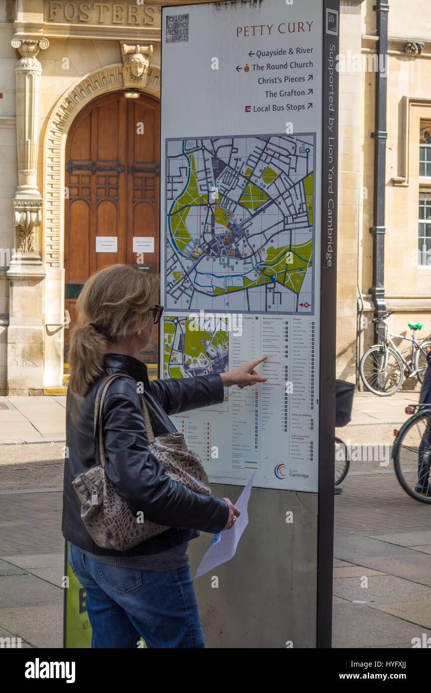 Lady-Touristen auf der Suche auf Karte von Cambridge Zentrum für Orte von Interesse Stockfoto