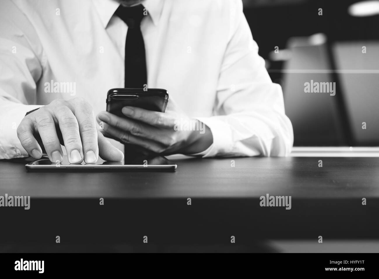 Rechtsanwältin in Zusammenarbeit mit smart-Phone und digital Tablet-Computer im modernen Büro, schwarz / weiß Stockfoto