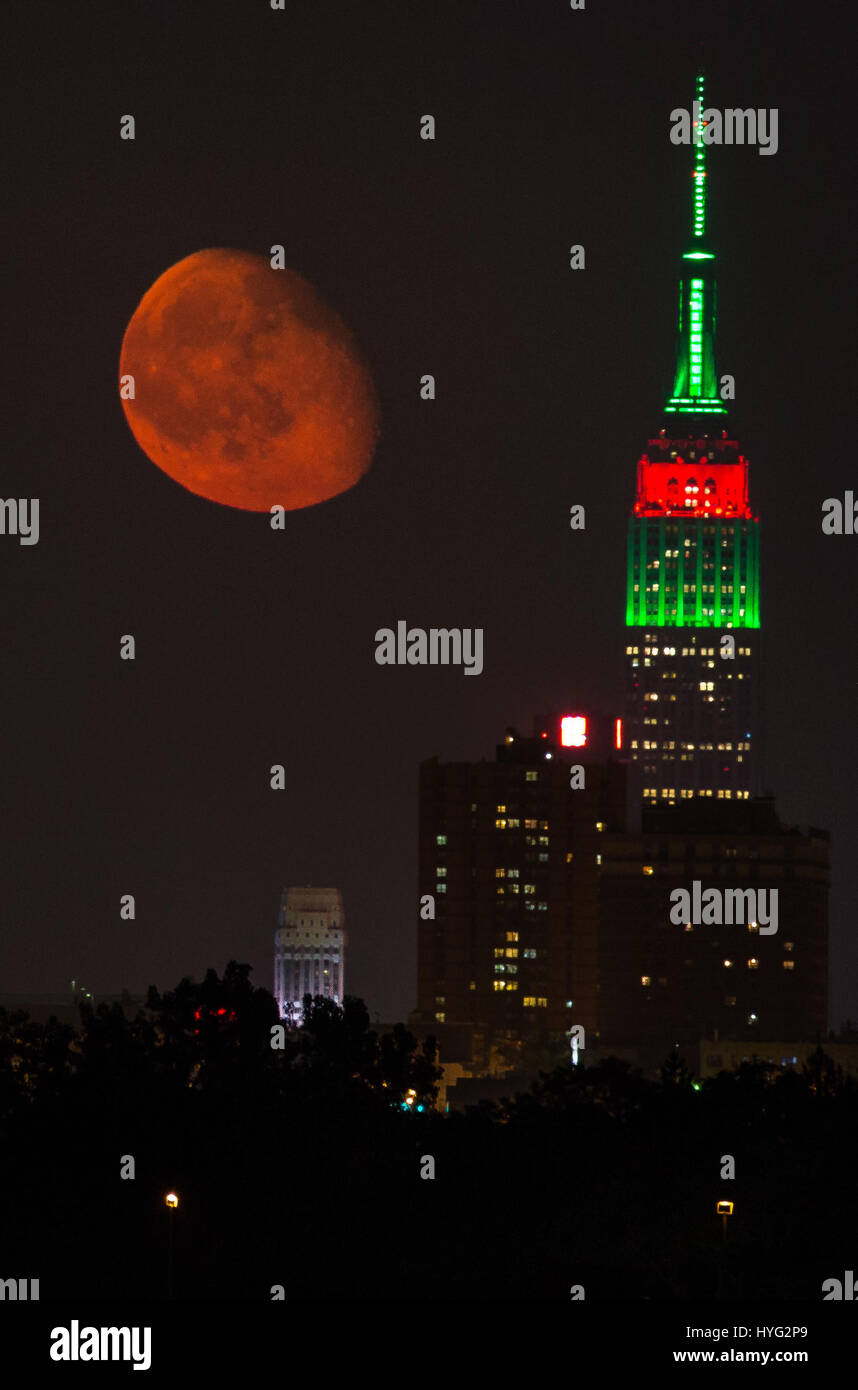 NEW YORK, USA: Atemberaubende Bilder von Empire State Building mit einem orange Mond vorbei Overhead wurden gefangen genommen. Die Bilder zeigen, wie eines der berühmtesten Gebäude der Welt mit unserem Mond leuchtend Orange Aufwand noch mehr beeindruckende aussah. Andere Bilder zeigen den Sonnenaufgang von Manhattan und die Brooklyn Bridge. Amerikanische Technische Redakteurin Jennifer Khordi (46) war in der Lage, diese beeindruckenden Aufnahmen von der Skyline von Jersey City und Kearny Stadt in New Jersey zu erfassen. Stockfoto