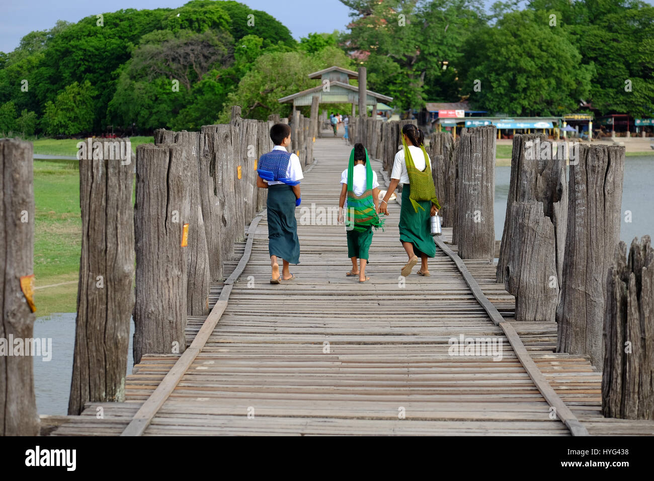Amarapura, Myanmar - 28. Juni 2015: Kinder in bunten Kleidern zu Fuß zur Schule auf U Bein Brücke in Amarapura, Myanmar Stockfoto