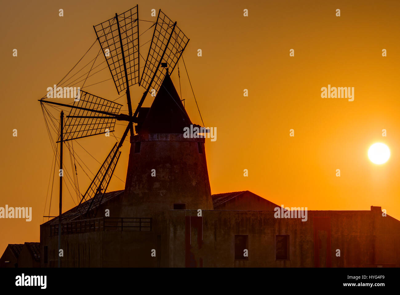 Windmühle bei Sonnenuntergang an die Salinen von Marsala auf Sizilien Stockfoto