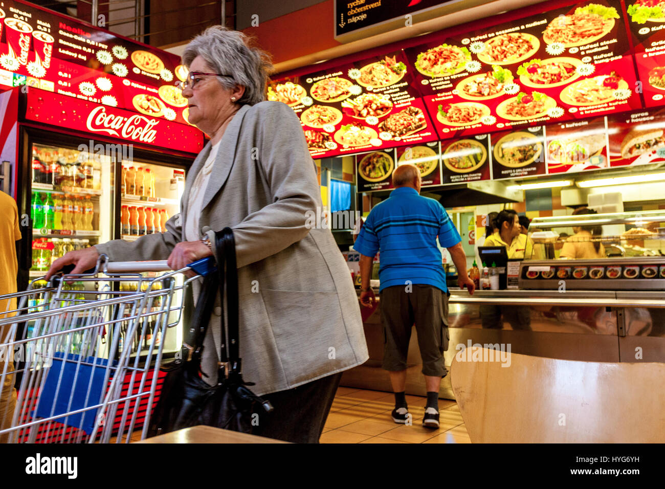 Seniorin, Supermarkt ältere Frau mit einem Einkaufswagen in Asien Fast Food Tschechien, Europa ältere Generation, die den Wagen schiebt Stockfoto