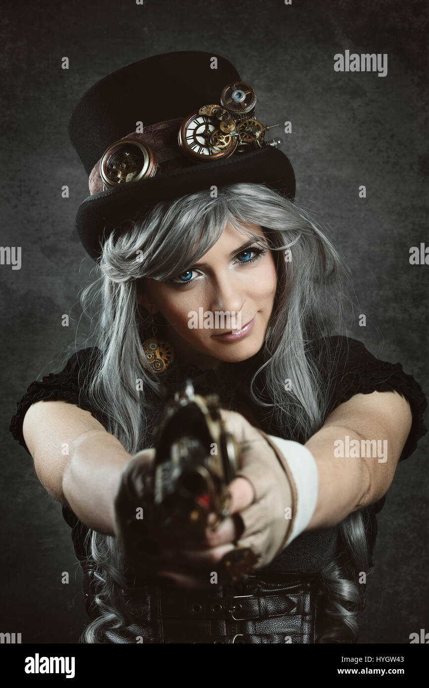 Steampunk gekleidete Frau mit einer Pistole auf Kamera Stockfoto