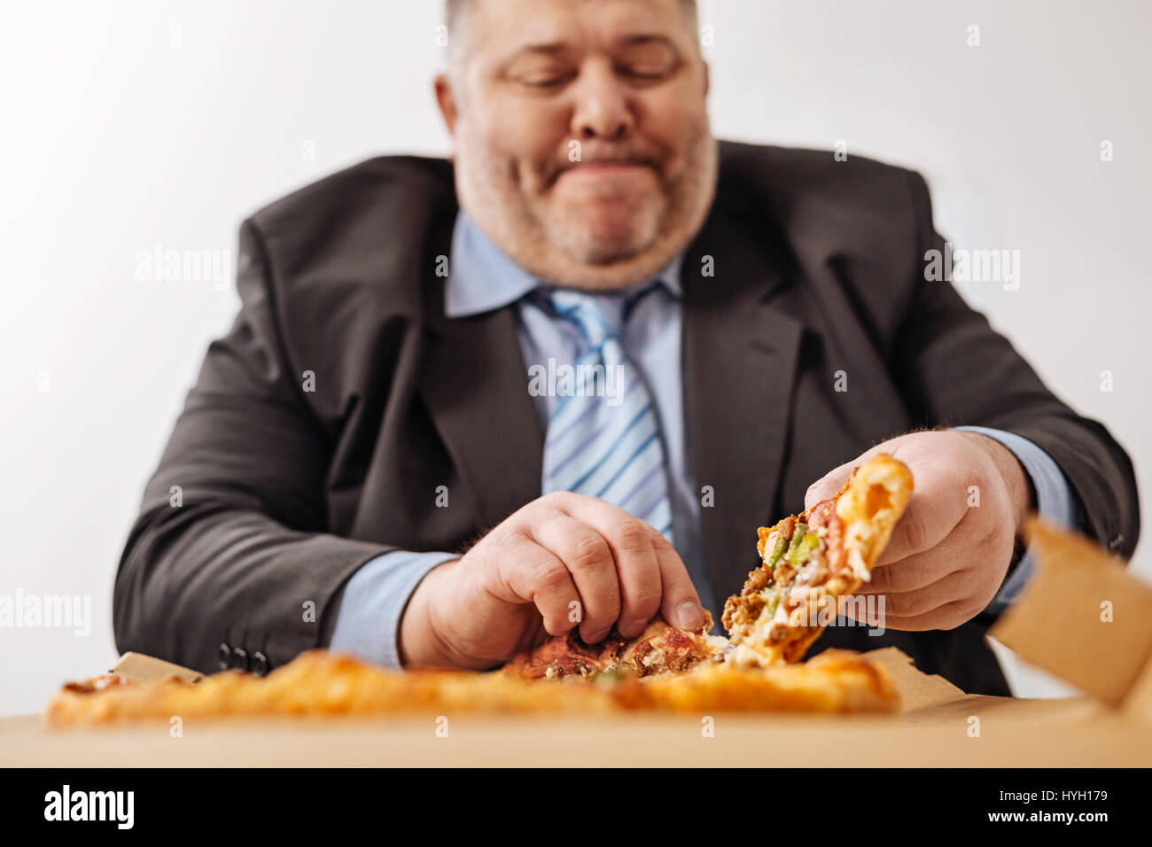 Geschwollene hungrigen Büroarbeiter sein Mittagessen zu genießen Stockfoto