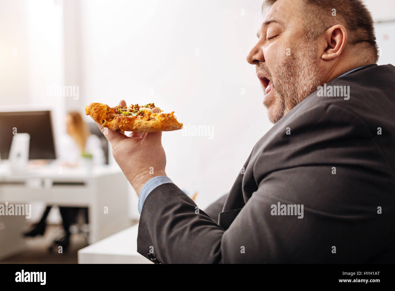 Ungesunde Büroangestellter genießen Essen Junk food Stockfoto