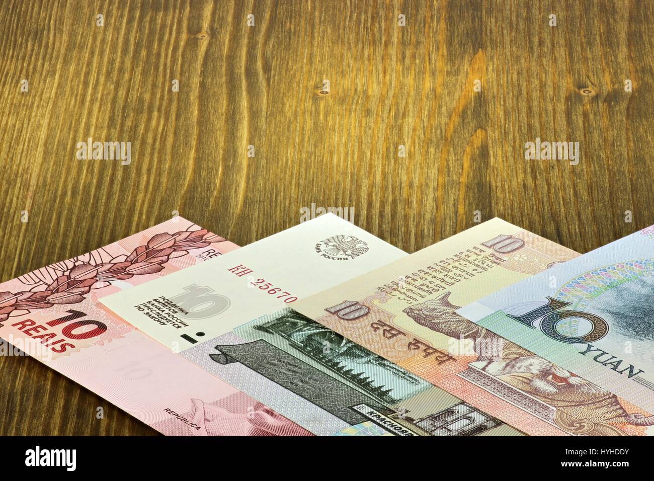 Banknoten der BRIC-Staaten auf hölzernen Hintergrund Stockfoto