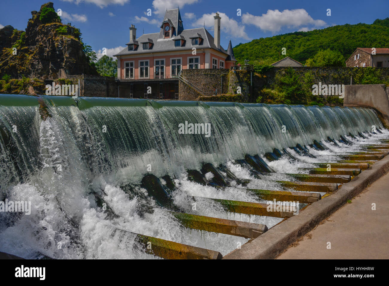 Das Wehr auf den Fluss Tarn, in Ambialet, Occitanie, Frankreich. Der alte Strom Krafthaus ist im Hintergrund. Stockfoto