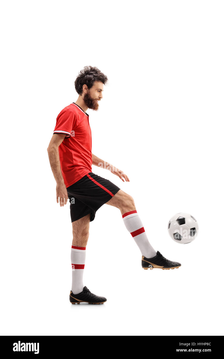 Voller Länge Profil Schuss von einem bärtigen Mann in einem roten Trikot jonglieren einen Fußball isoliert auf weißem Hintergrund Stockfoto