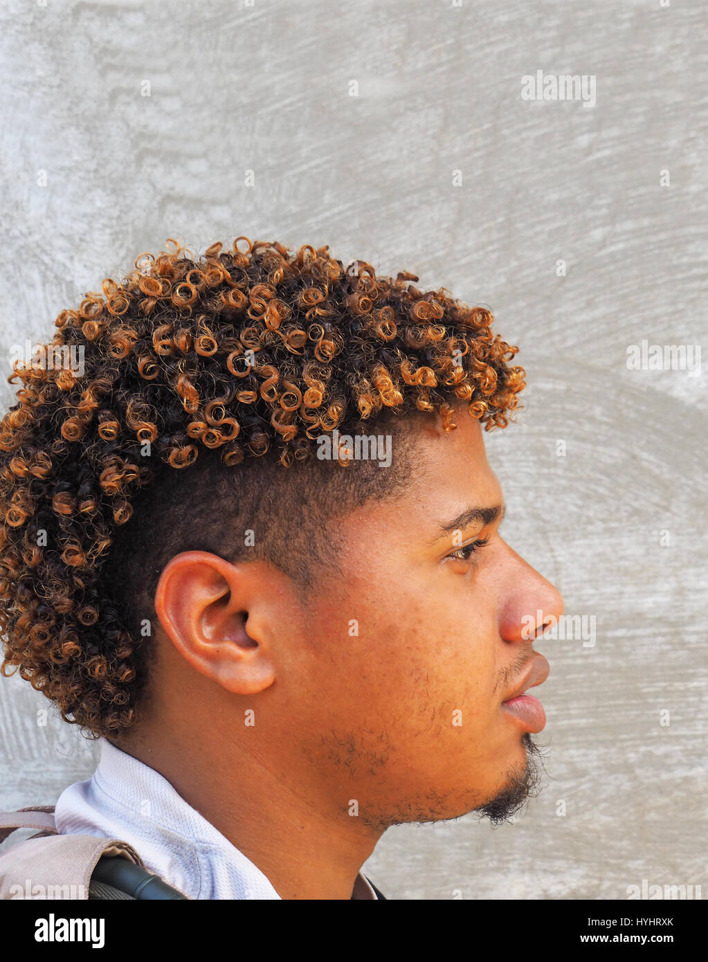 Profil von Dominikanischen Jüngling mit bunten Frisur in Puerto Plata. Stockfoto