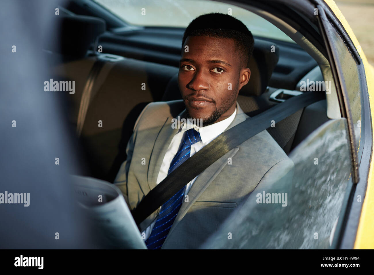 Afrikanischen Geschäftsmann lesen Zeitung im Auto Stockfoto