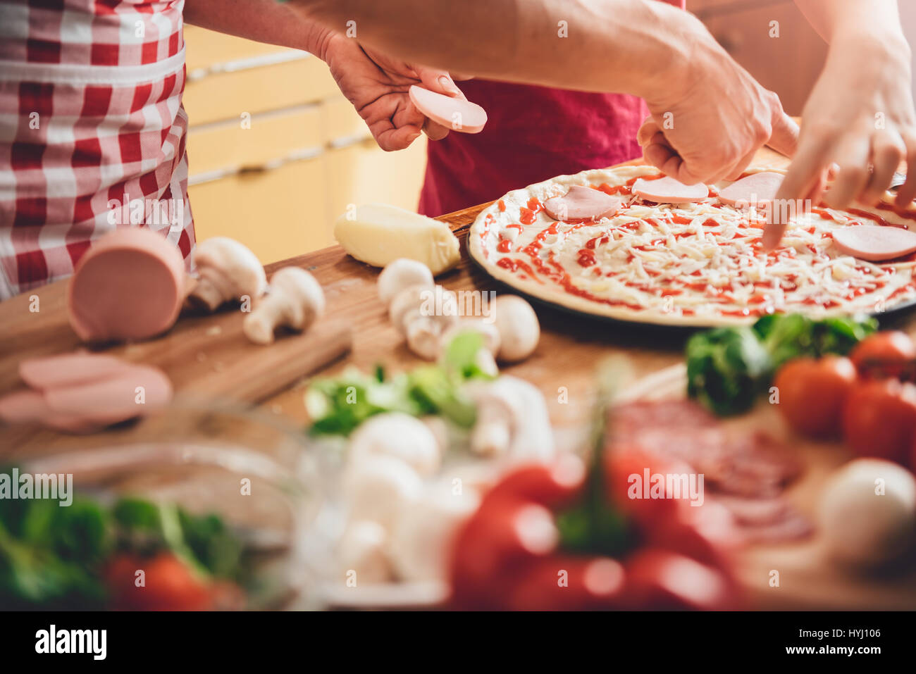 Mutter und Tochter, die Pizza in der Küche vorbereiten Stockfoto
