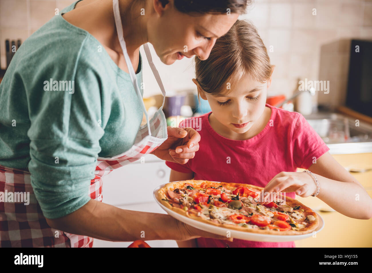 Mutter und Tochter Verkostung frischen gebackenen pizza Stockfoto