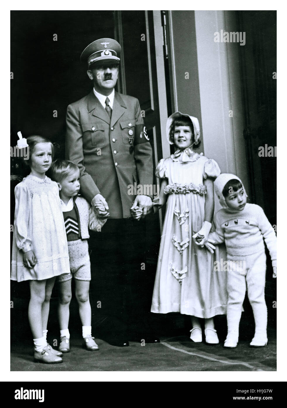 Adolf Hitler in Uniform mit Hakenkreuz Armbinde außerhalb seiner alpine Chalet in Berchtesgaden posiert auf seinem 50. Geburtstag mit einer Gruppe von Kindern aus hochrangigen NS-Beamten 20. April 1939 Stockfoto