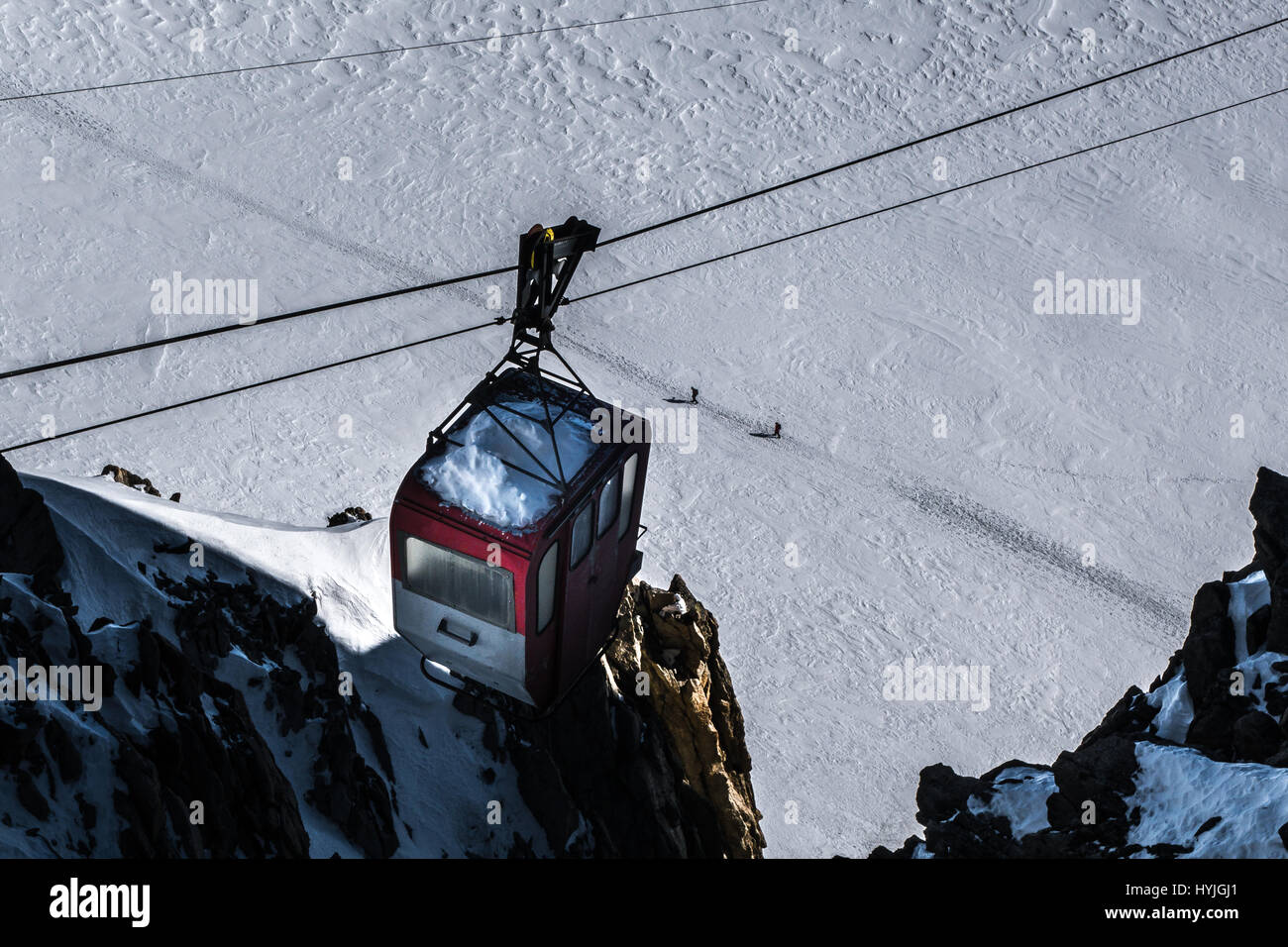 Stillgelegten Seilbahn über Klippen mit Blick auf windigen Gletscher mit Skifahrer im Winter unter traversin Stockfoto
