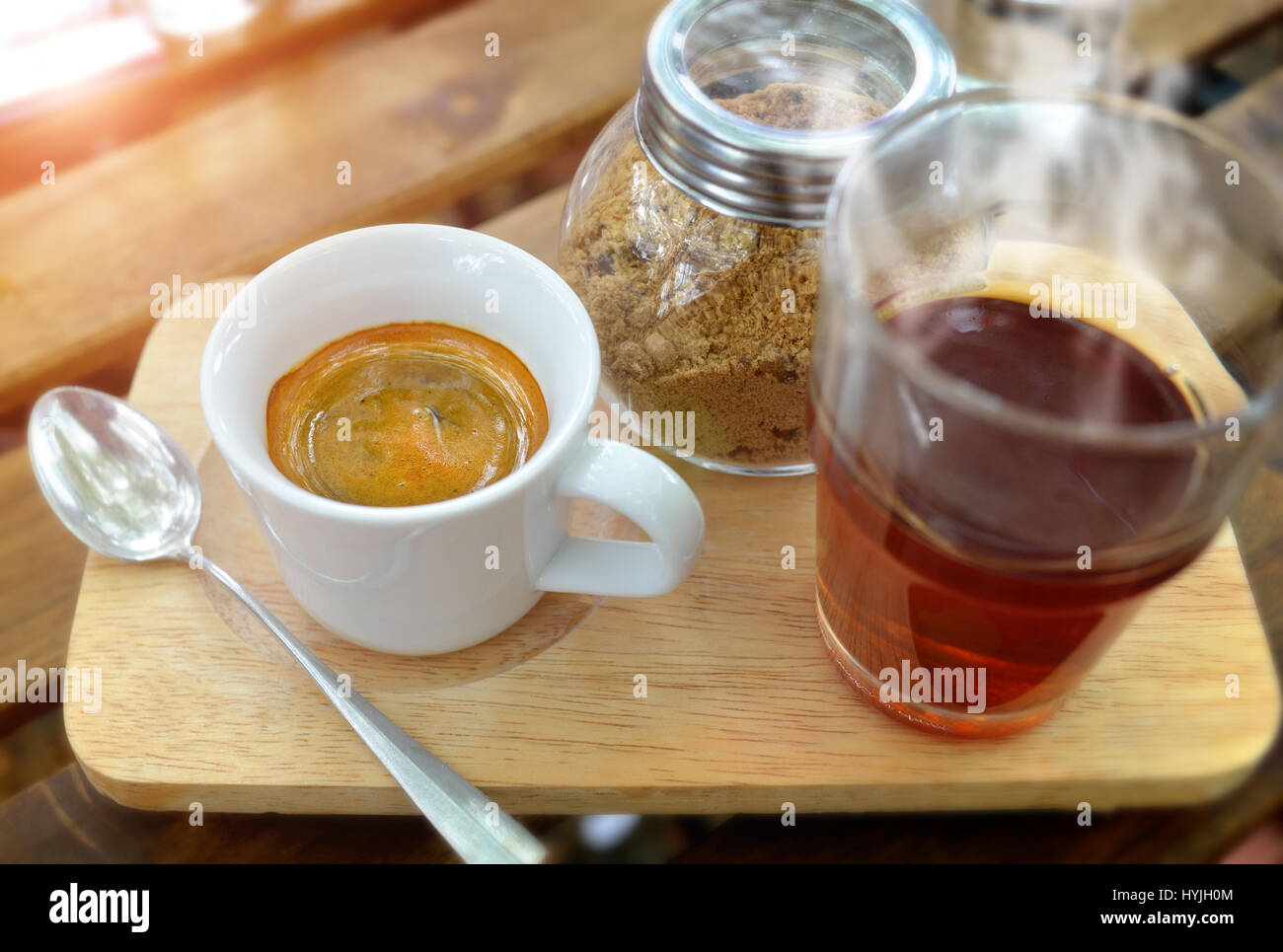 Schuss in kleine Tasse Espresso-Kaffee servieren mit roter Tee und Zucker in Outdoor-tiefstehende Sonne Beleuchtung. Stockfoto