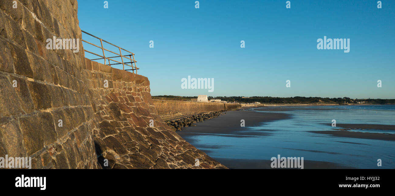 Der Deich von St-Ouen Bay, Jersey bei Ebbe mit exponierten Sandbänken in der Sommersonne am Nachmittag Stockfoto