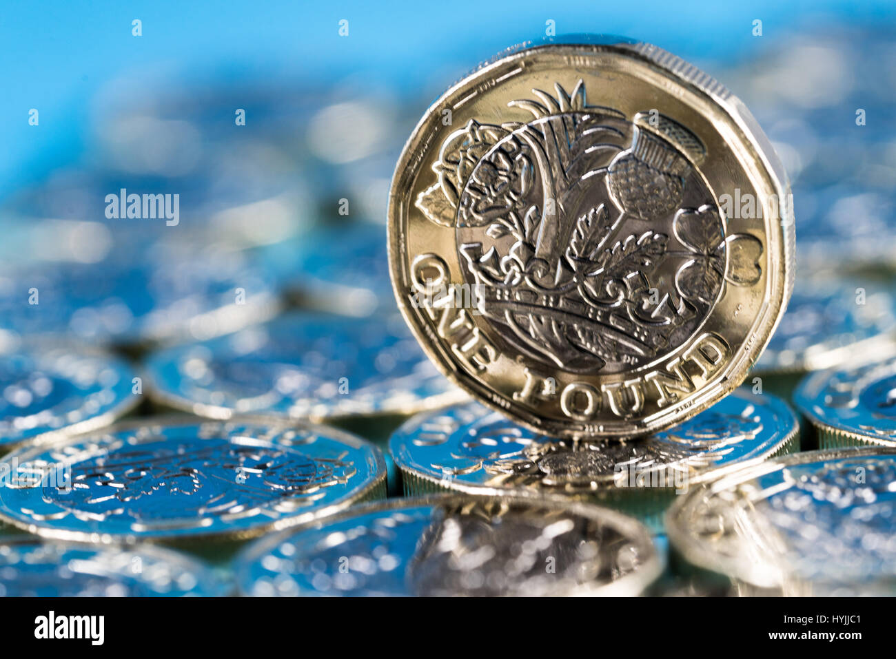 neue Pfund-Münze eingeführt in Großbritannien im Jahr 2017, Front, stehend auf einer Schicht von Münzen und auf blauem Hintergrund Stockfoto
