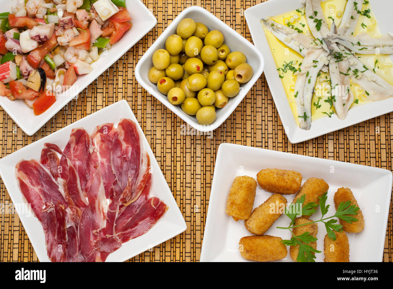Essen. Traditionelle Tapas der andalusischen Gastronomie. Iberischer Schinken mit schwarze Pfote, Meeresfrüchte Salpicon, Sardellen in Essig, Kroketten von Schinken und Oliven Stockfoto
