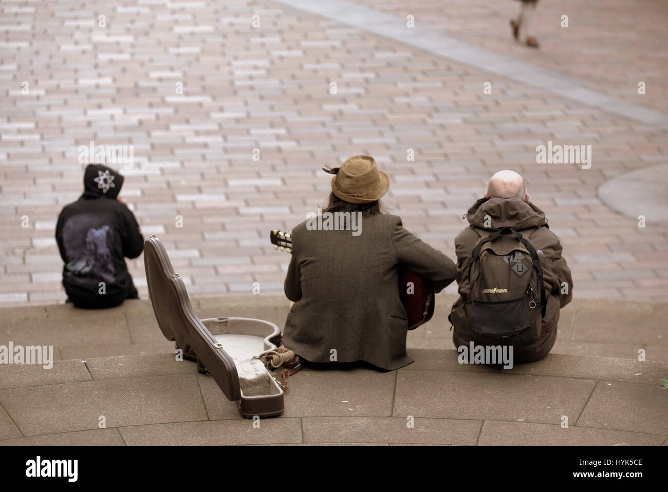 Glasgow Straße Szene Stadtbild Jugendliche Touristen sitzen auf Stufen beobachten Leben vorbeiziehen Stockfoto