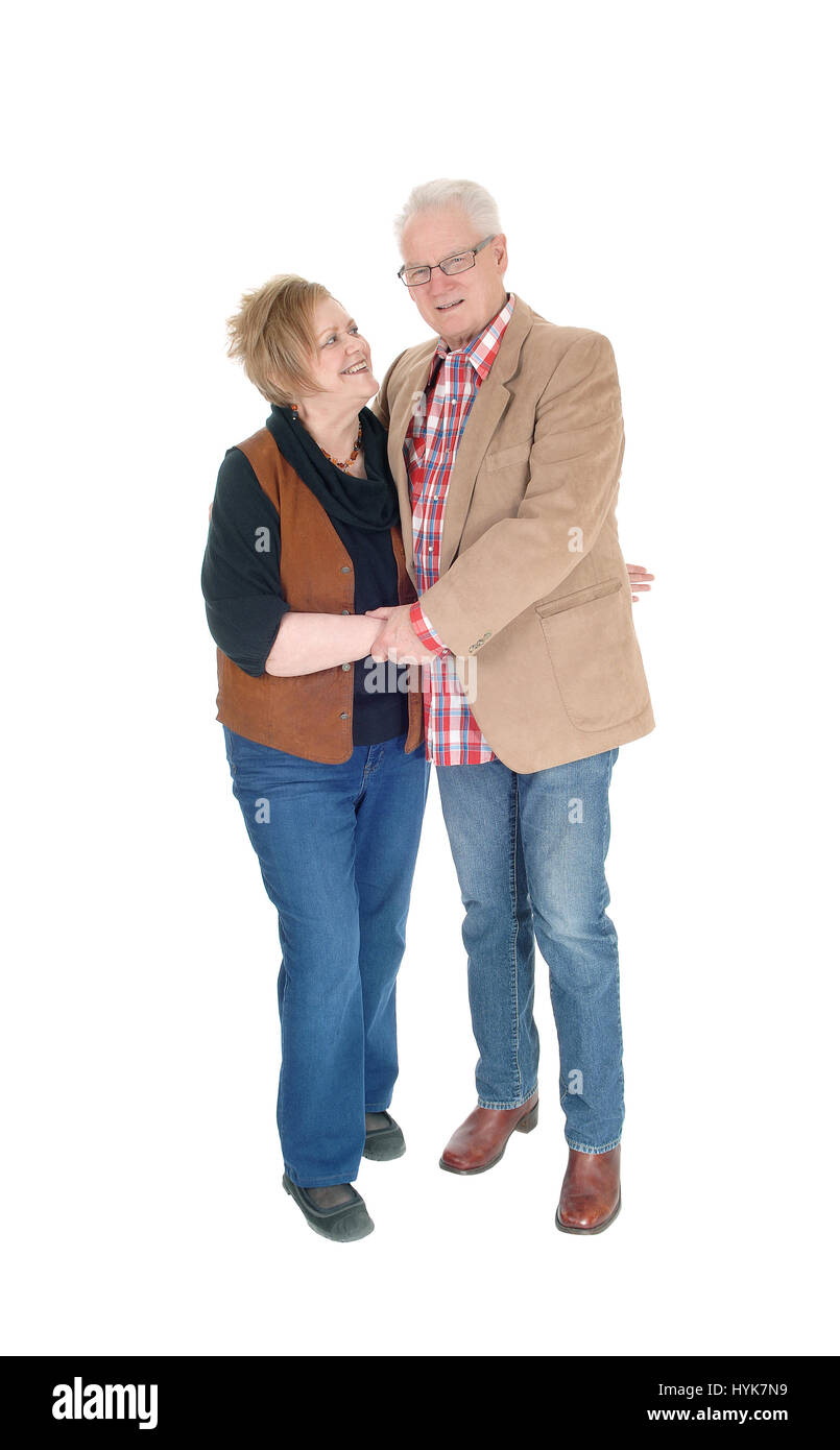 Eine schöne älteres Ehepaar im lässigen Tuch stehen, einander umarmen, isoliert lächelnd, weißen Hintergrund. Stockfoto