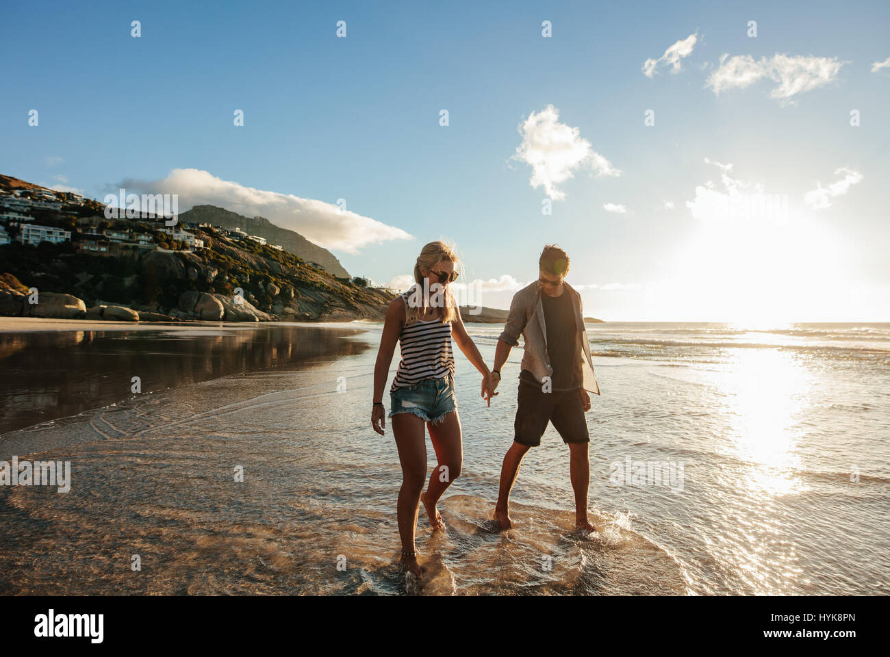 Im Freien Schuss glückliches junges Paar am Strand Hand in Hand. Junger Mann und Frau Strandurlaub zu genießen. Stockfoto