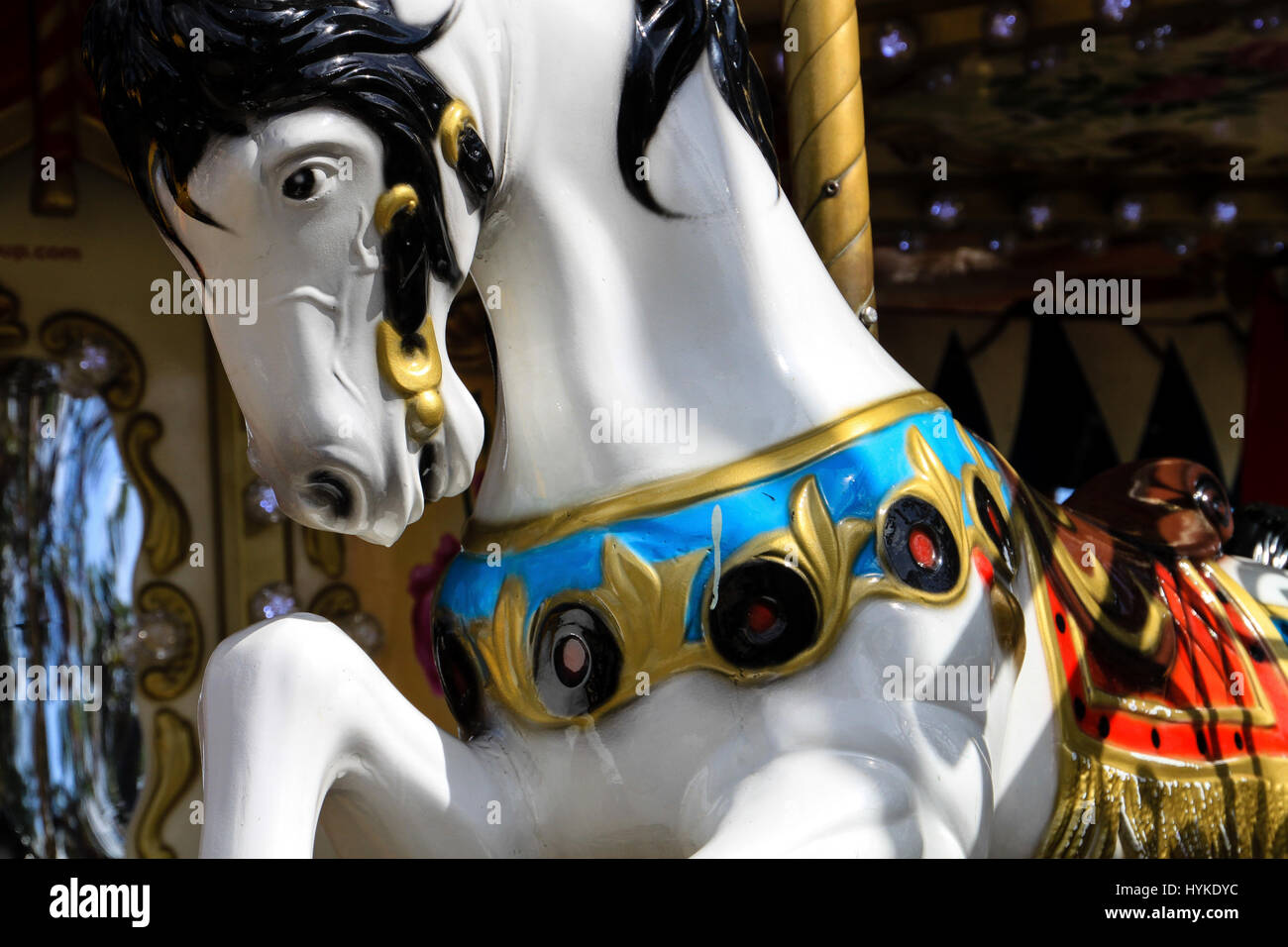 Ein Karussell in Paris. Nahaufnahme von einem schönen weißen Pferd mit schwarzer Mähne und bunten Accessoires warten auf einen Fahrer an einer merry Go round in Frankreich. Stockfoto