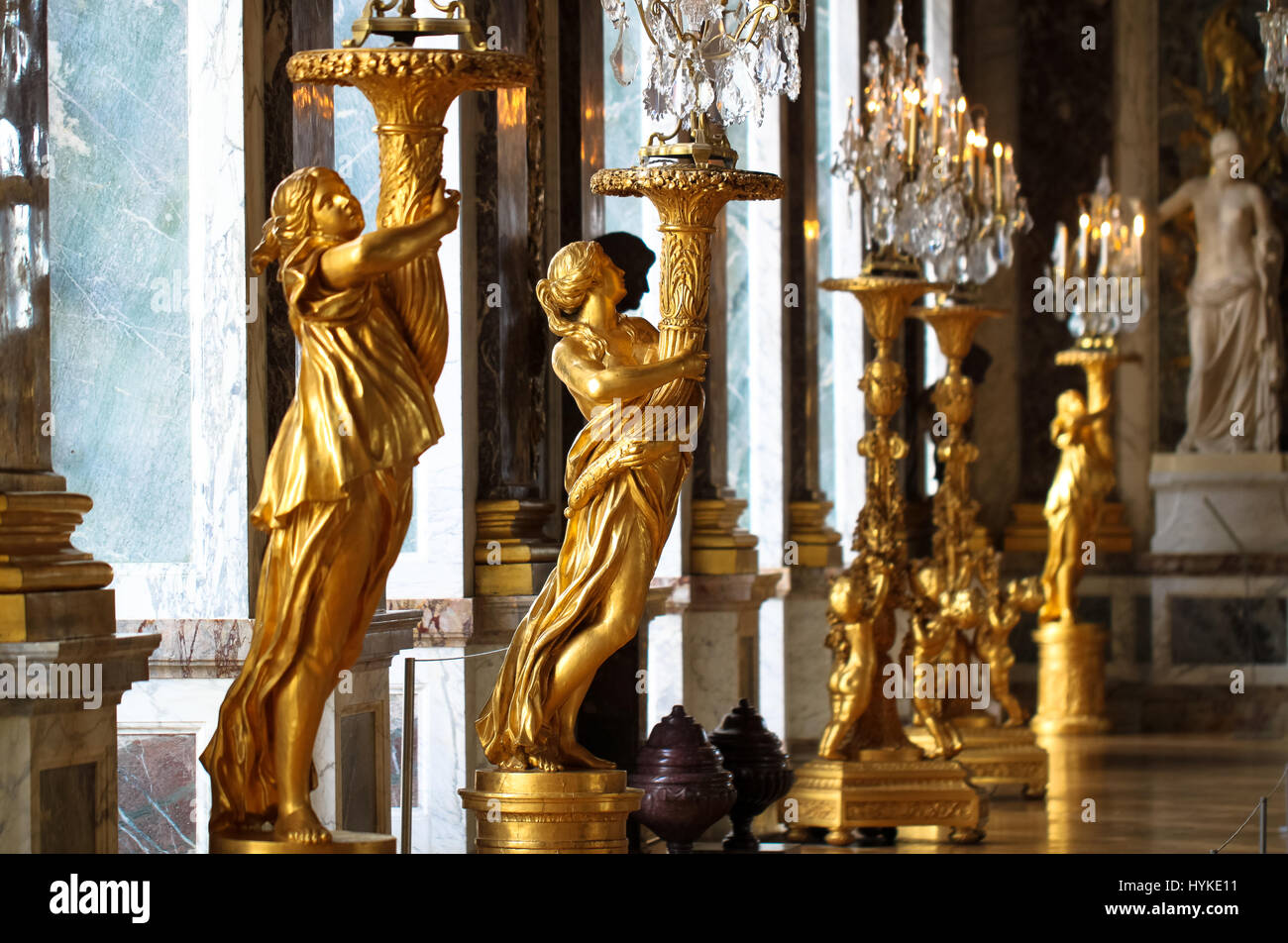 Hall of Mirrors, Versailles, Frankreich.  Gold-Barock-Statuen Hintergrundbeleuchtung von sonnigen Fenstern in der großen Halle. Stockfoto