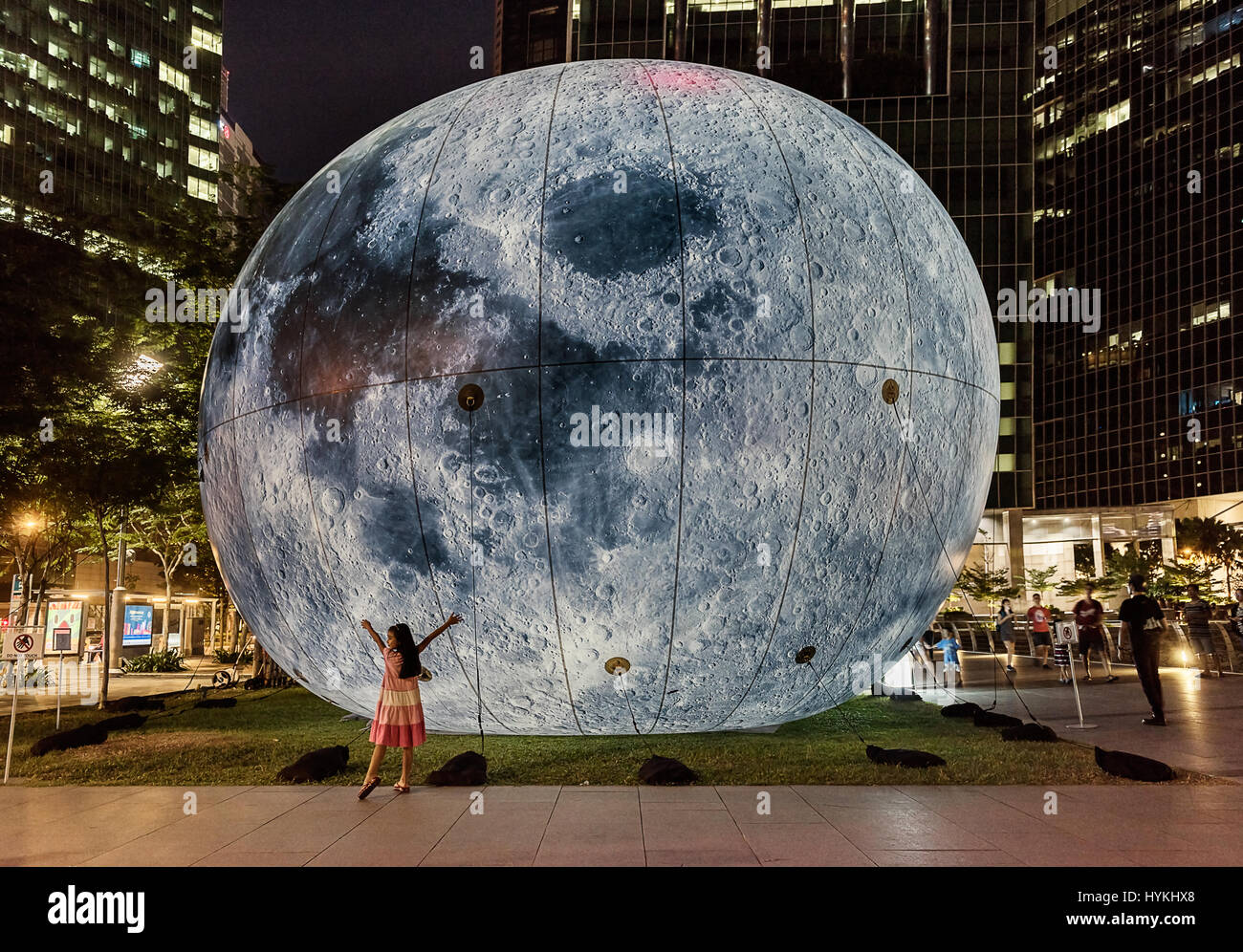 MARINA BAY, Singapur: Dieser Lichtinstallation namens Mond Dunst auch Funktionen als ein monitoring-System für Luftschadstoffe, Abholung und die Reaktion auf die Luftqualität.  Desto besser die Qualität der Luft, desto heller die Installation. Ein KALEIDESCOPIC Lichterfest statt beleuchten eine ikonische Waterfront-Arena. Läuft ab 4 – 27 März 2016 Bilder zeigen lokale Bewohner, die Teilnahme an dieser jährlichen Veranstaltung, der darauf abzielt, durch die Verwendung von ökologisch nachhaltige Sensibilisierung Licht Kunst-Installationen. Kinder und Erwachsene können gesehen werden, im bunten Licht von th gebadet werden Stockfoto