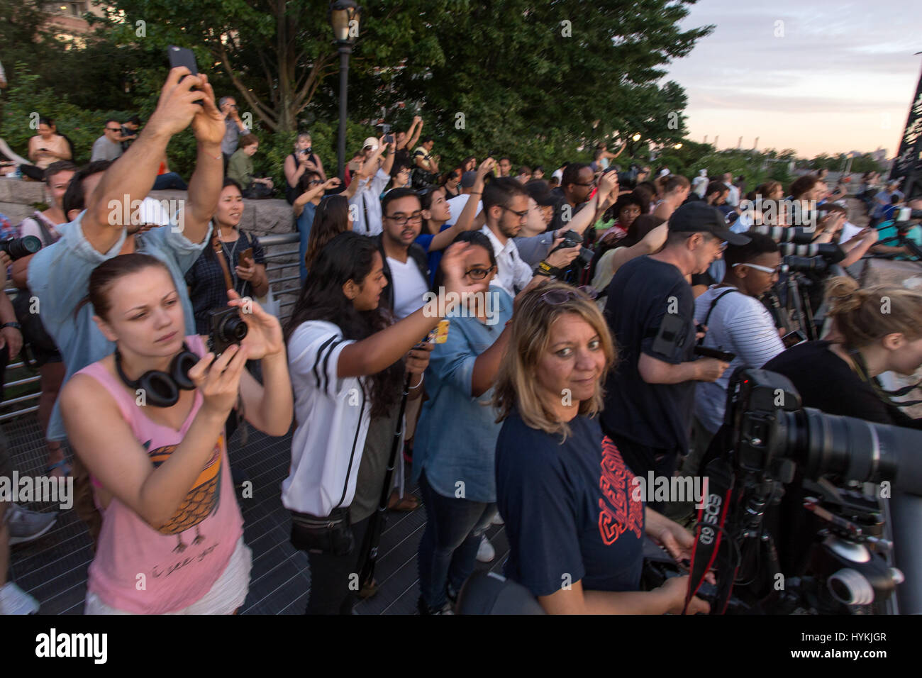 New York City, USA: IN A Hommage Großbritanniens legendäre Stonehenge-Versammlungen, die New Yorker strömten, um Zeuge die Sonne als es auf den letzten "Manhattanhenge" 2016 eingestellt. Bilder zeigen wie Sonnenanbeter standen staunend als der prallen Sonne langsam stieg zwischen den Türmen von 42nd Street – die Herzen ihrer Stadt zu lokalen New Yorker genannt. Das solar-Ereignis tritt nur zweimal pro Jahr, wenn die Sonne genau über die Straßen von Manhattan Osten Westen schneidet. Die letzte wurde am 28. Mai dieses Jahres gesehen. NYC-Fotograf Peter Alessandria beschrieb die Szene. Stockfoto