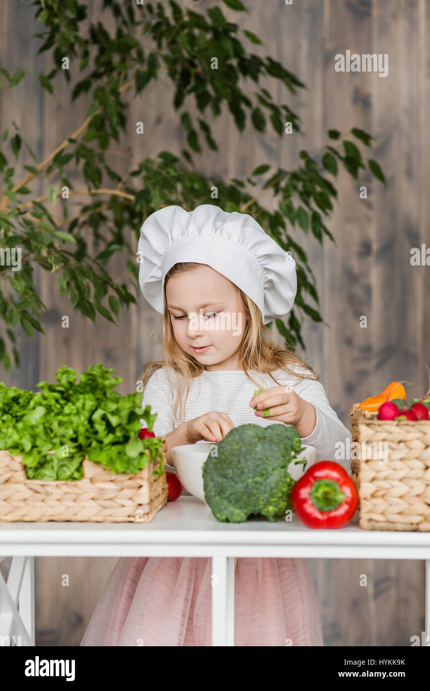 Schöne Mädchen machen Salat Gemüse in der Küche. Gesunde Ernährung. Kleine Hausfrau Stockfoto