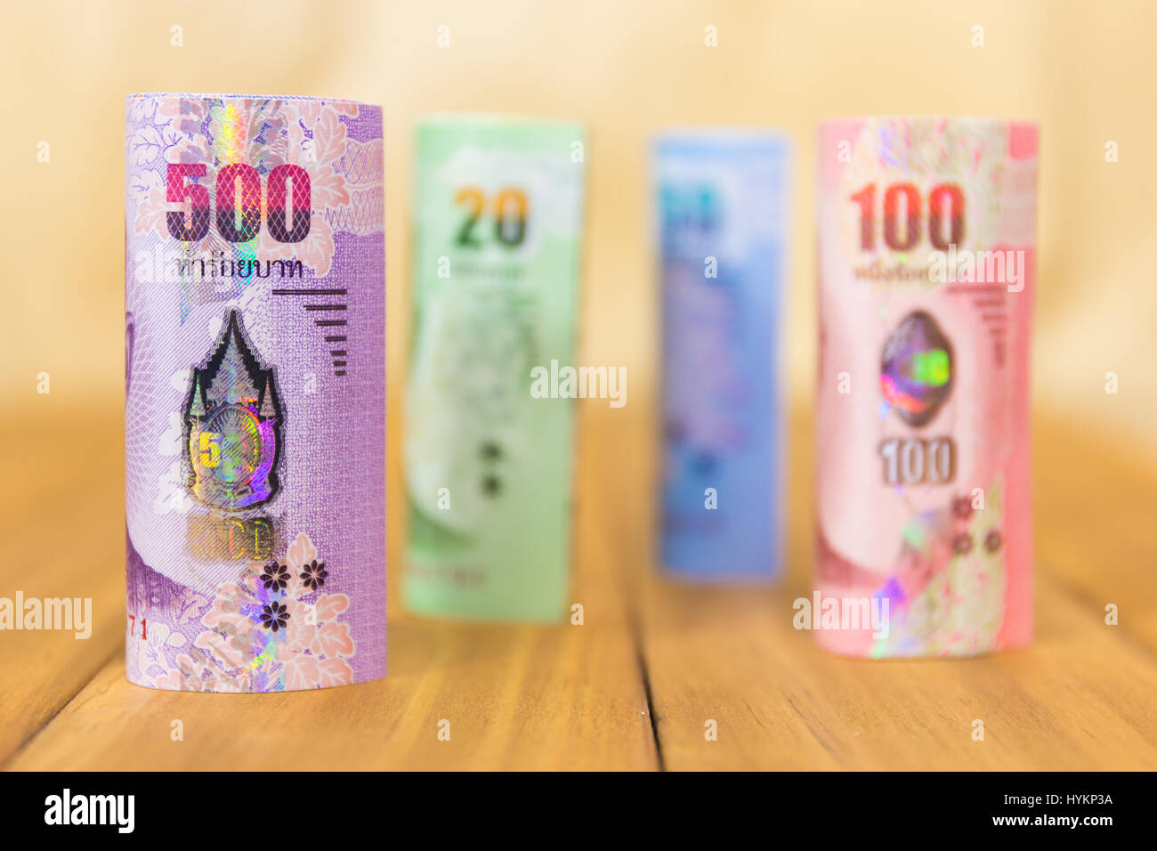 Thailand-Banknoten durch Wert gestapelt. Thailändische Banknoten rollt. Thailändische Währung Geld. Banknoten auf einander gestapelt in verschiedenen Positionen. Auf Holz Hintergrund Stockfoto