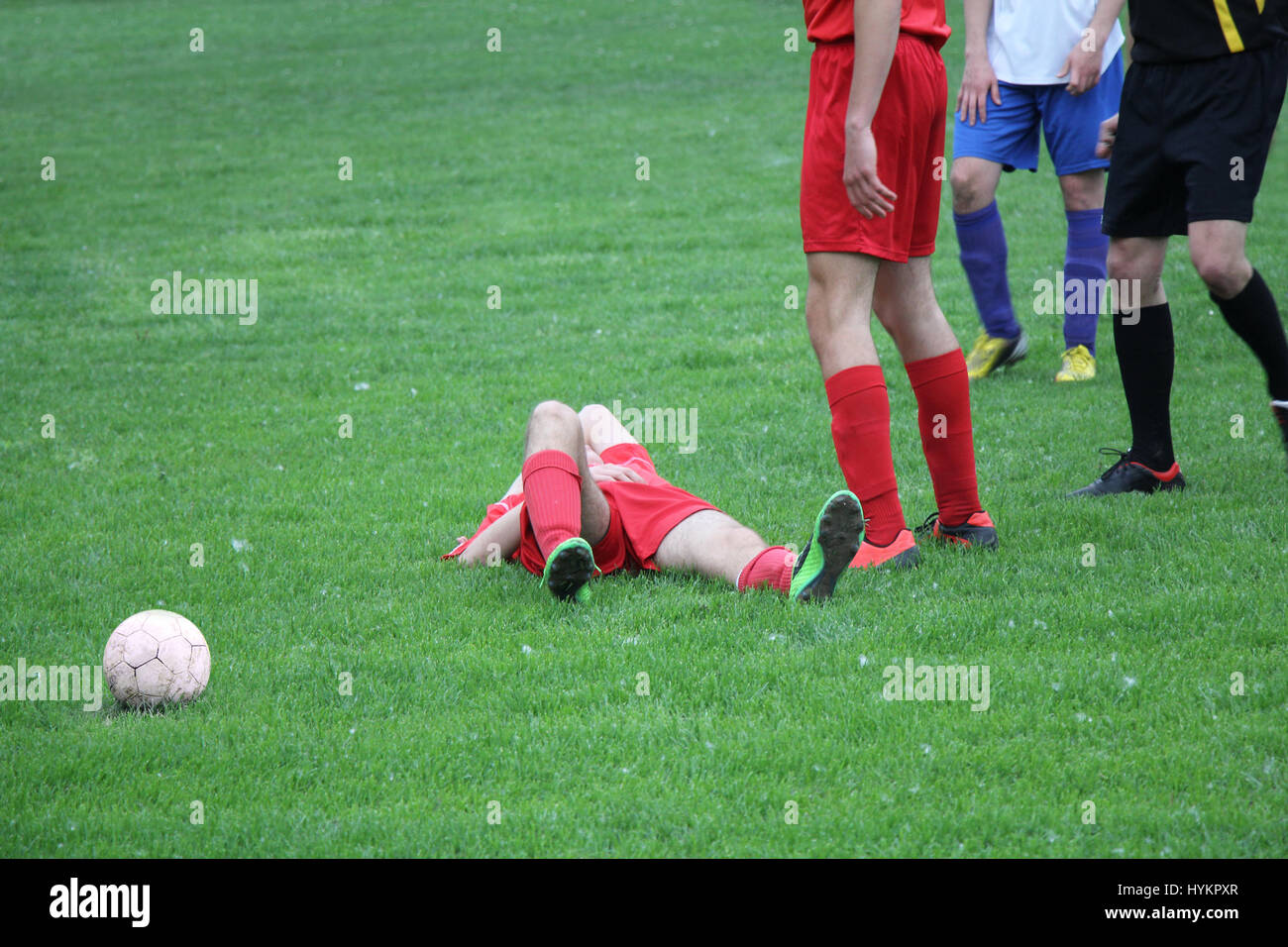 Verletzte Spieler beim Fußballspiel auf dem Rasen liegend Stockfoto