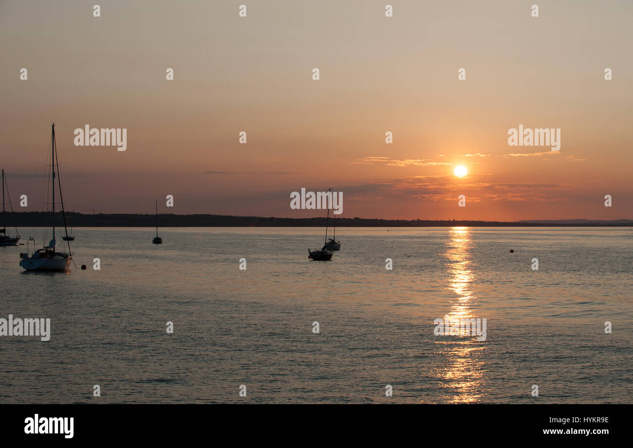 Silhouette Boote im Morgengrauen auf ruhiger See am Hafen von Skerries, Irland Stockfoto