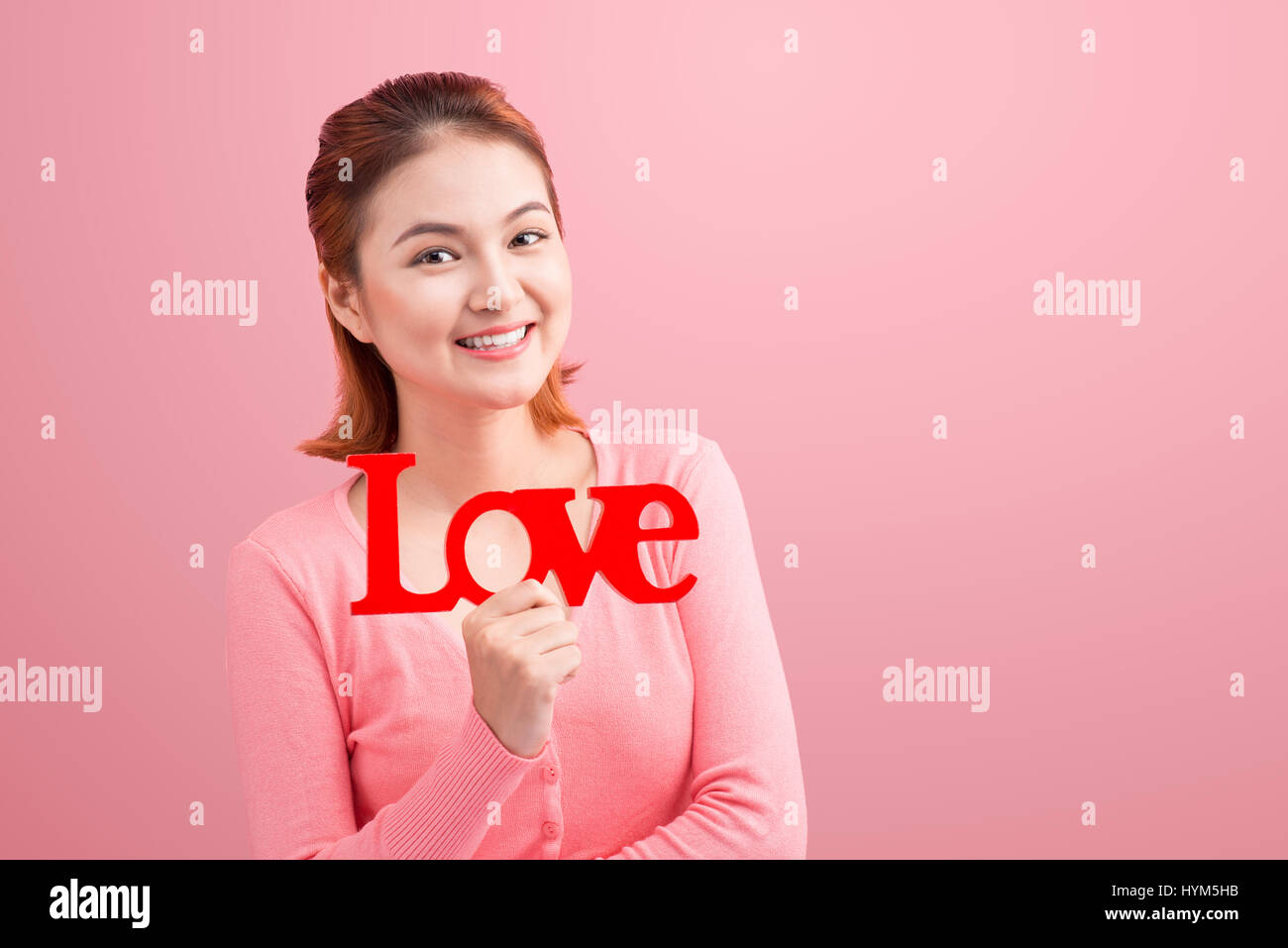 Ziemlich junge Asiatin Holzbuchstaben Liebe auf Link Hintergrund halten. Stockfoto
