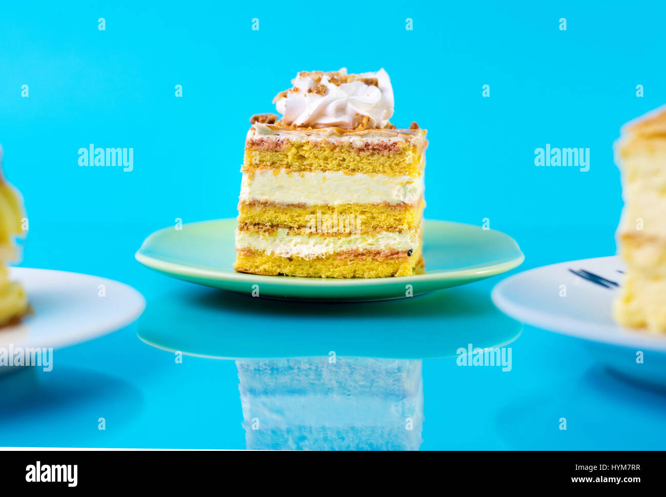 Süße Kuchenstücke vor blauem Hintergrund Stockfoto